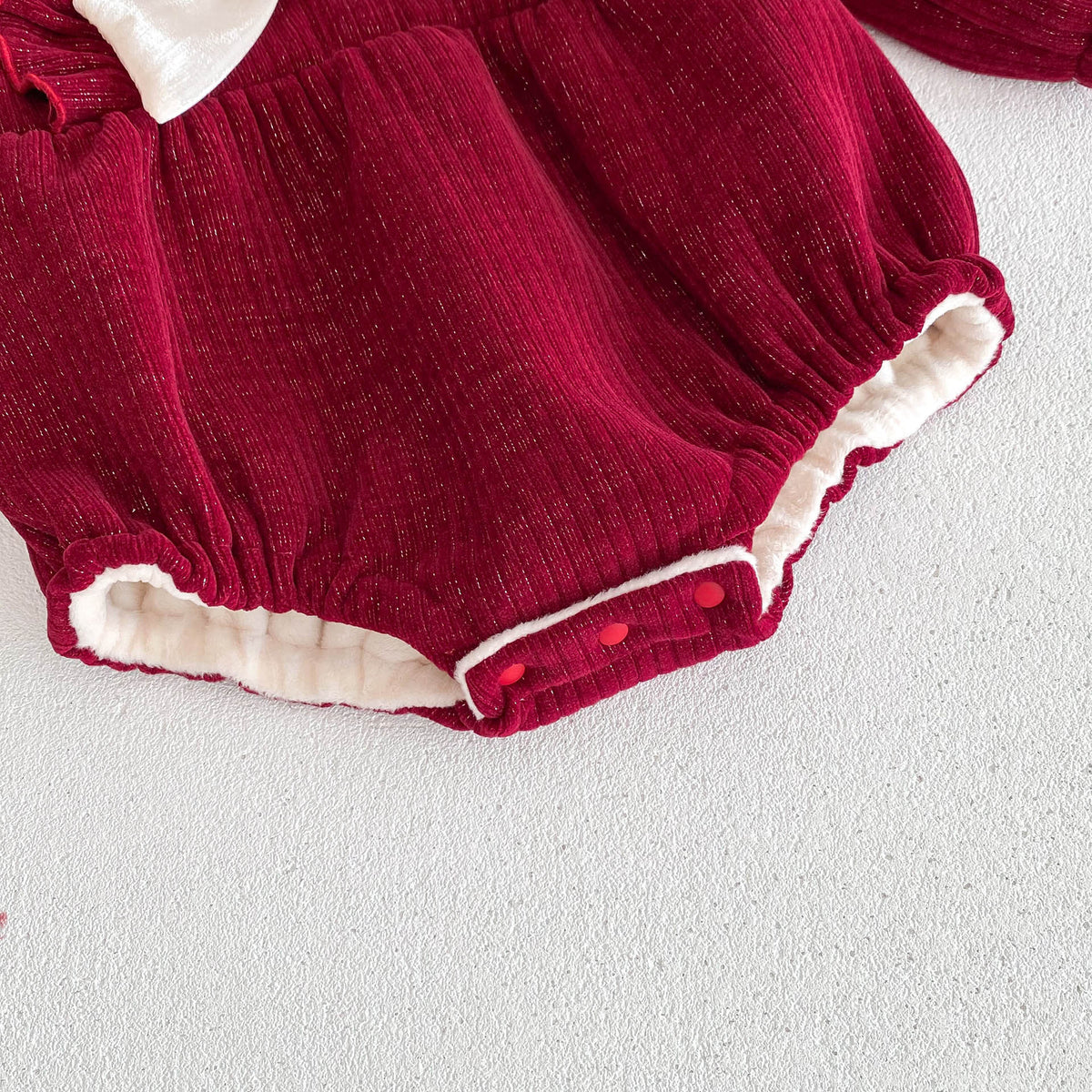 Close-up of leg opening and snaps on red romper