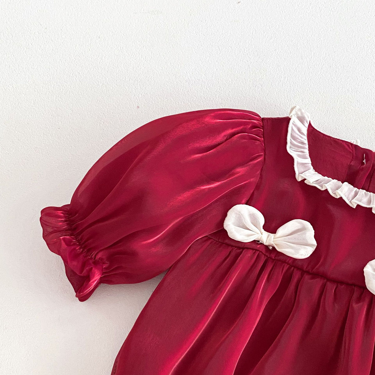 Close-up of puff sleeve and bow on red romper