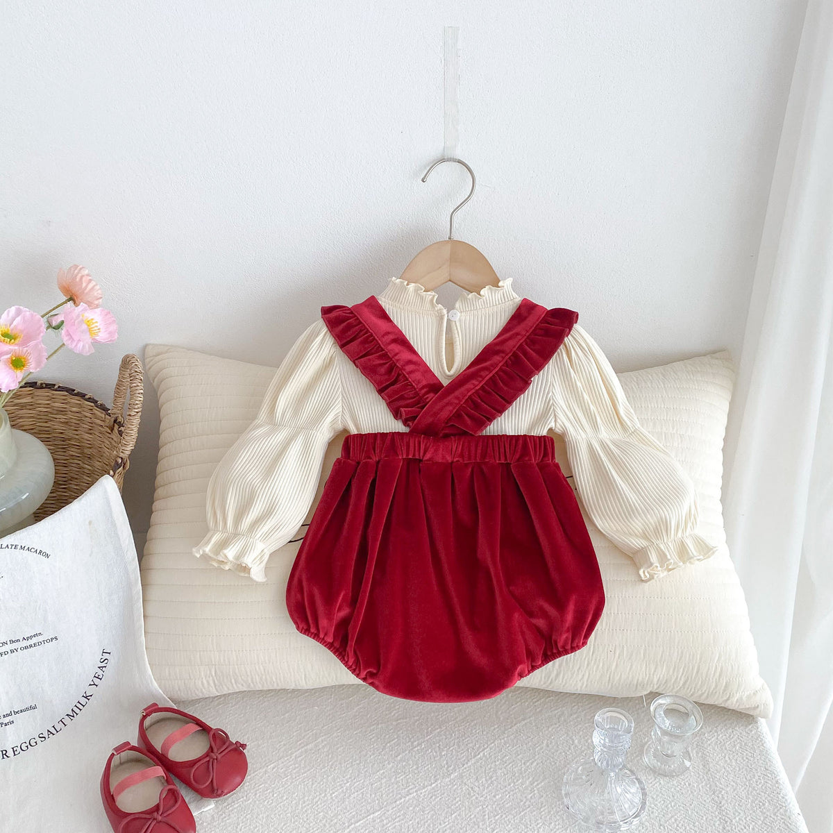 Red velvet suspender romper with bow over cream blouse