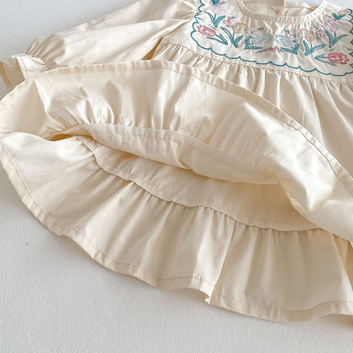 Close-up of tiered ruffle hem on cream girls dress