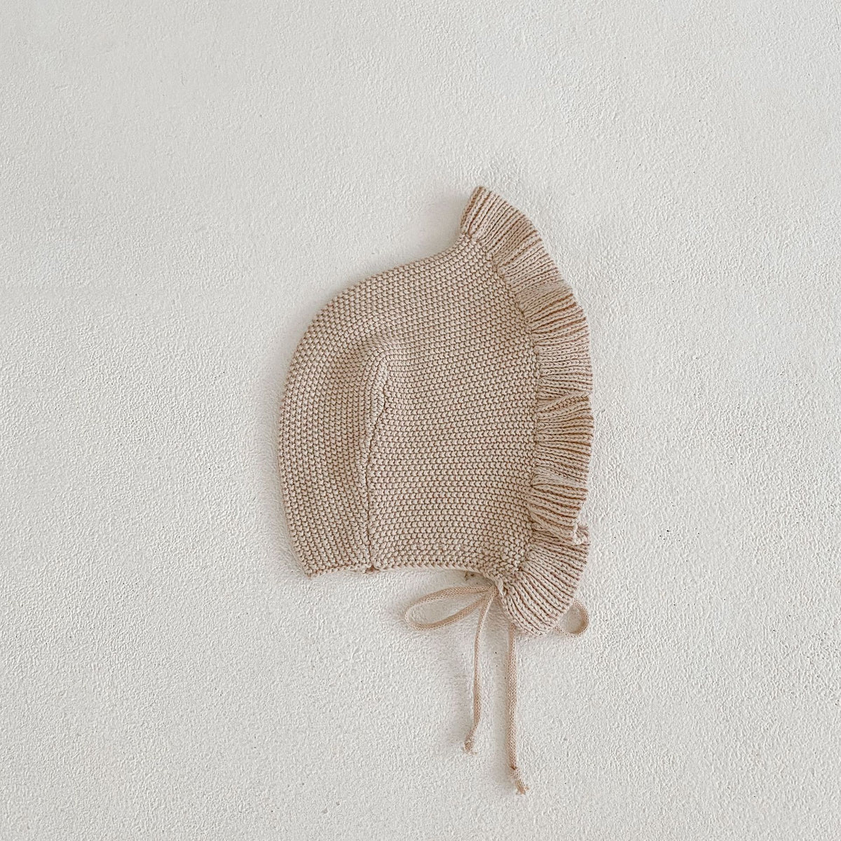 Oatmeal knit baby bonnet with ruffle edge and ties