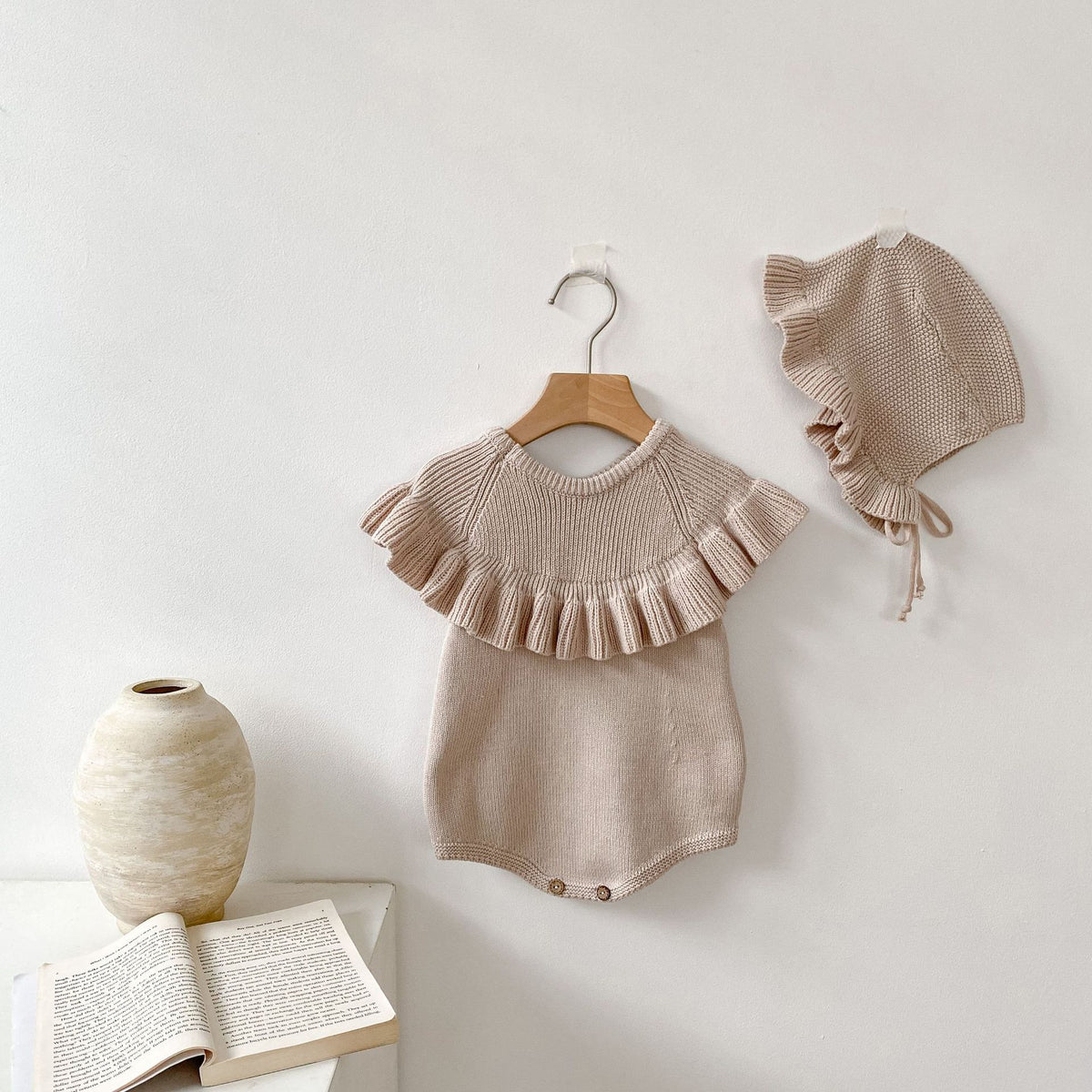Oatmeal ruffle collar knit baby romper and matching bonnet on hangers