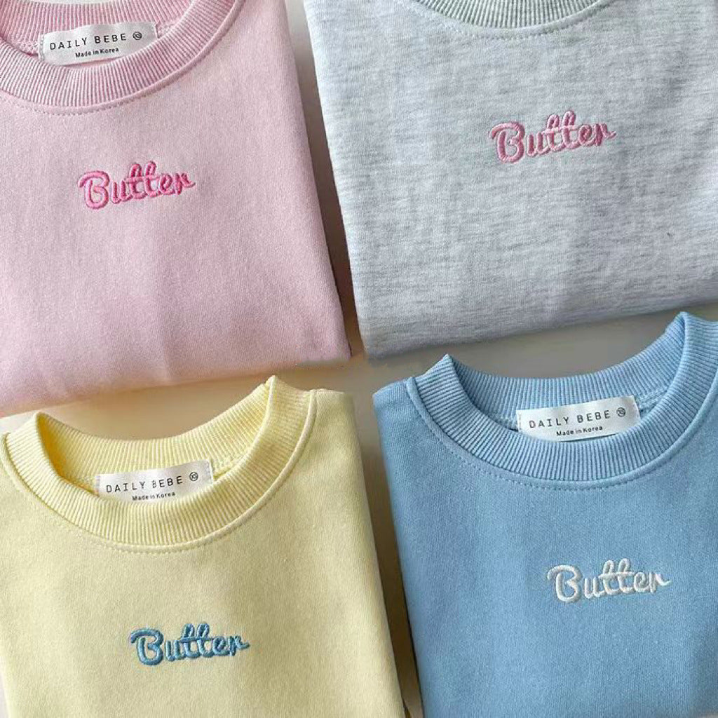 Close-up of script embroidery on pastel sweatshirts