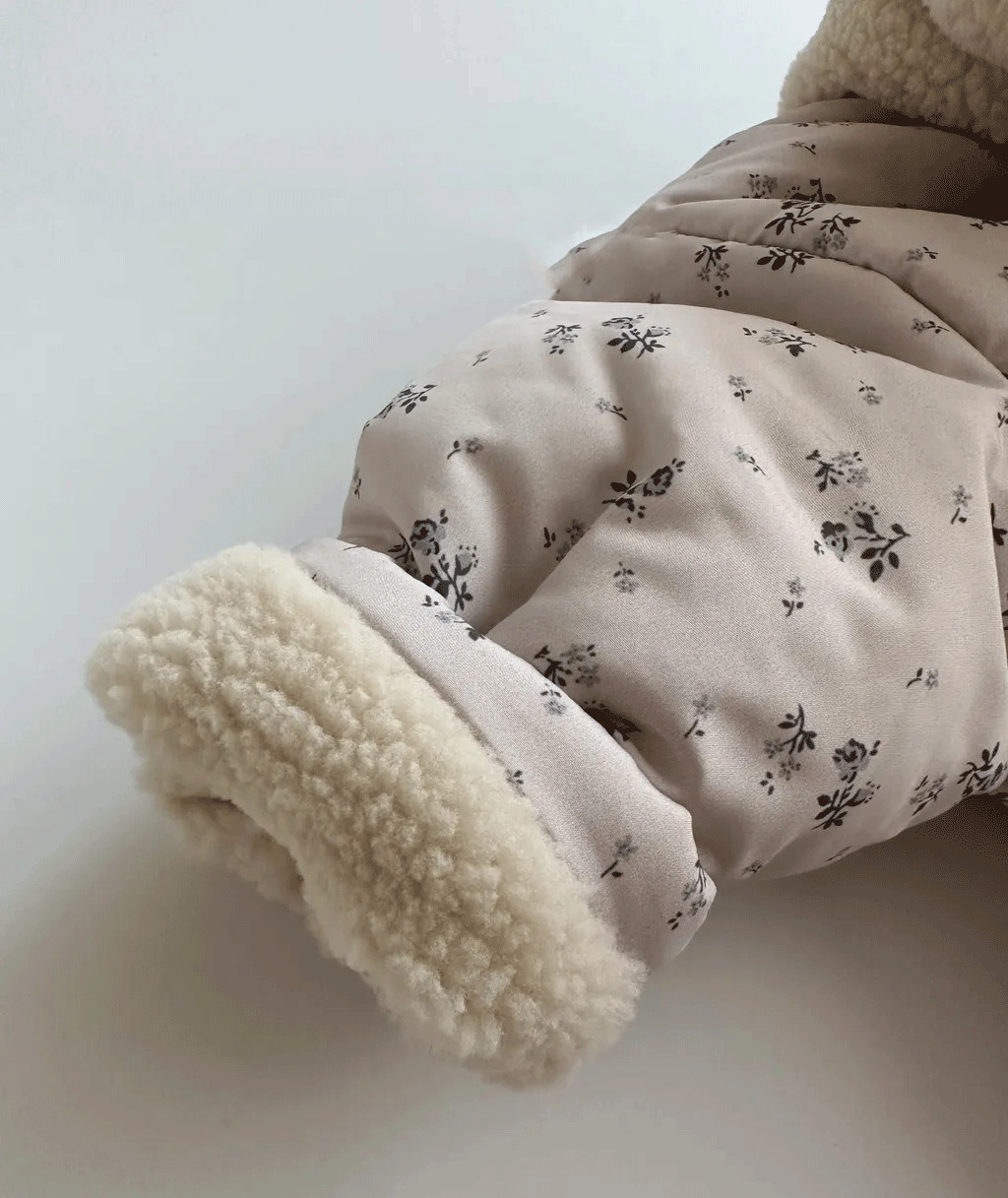 Close-up of sherpa cuff on floral jacket sleeve
