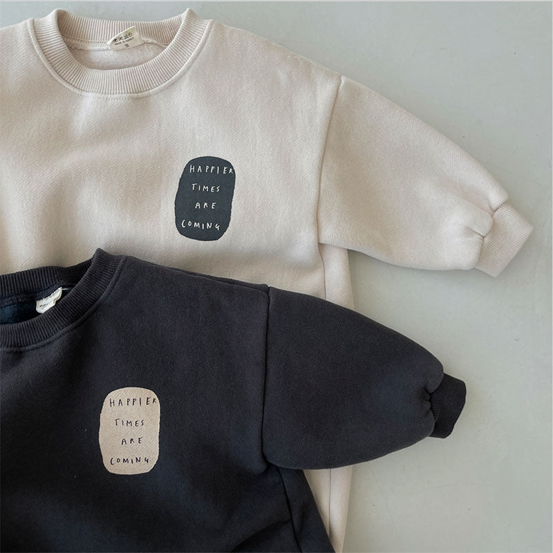 Close-up of printed patch on beige and black sweatshirt rompers