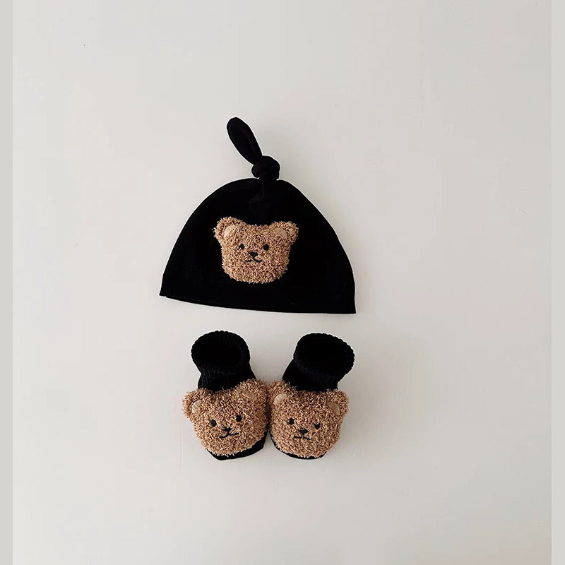 Black knot baby beanie and socks with fluffy teddy bear faces, flat lay
