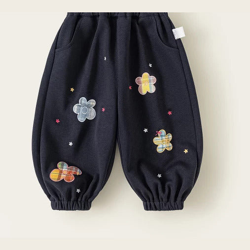 Navy girls jogger pants with plaid flower patches, flat lay