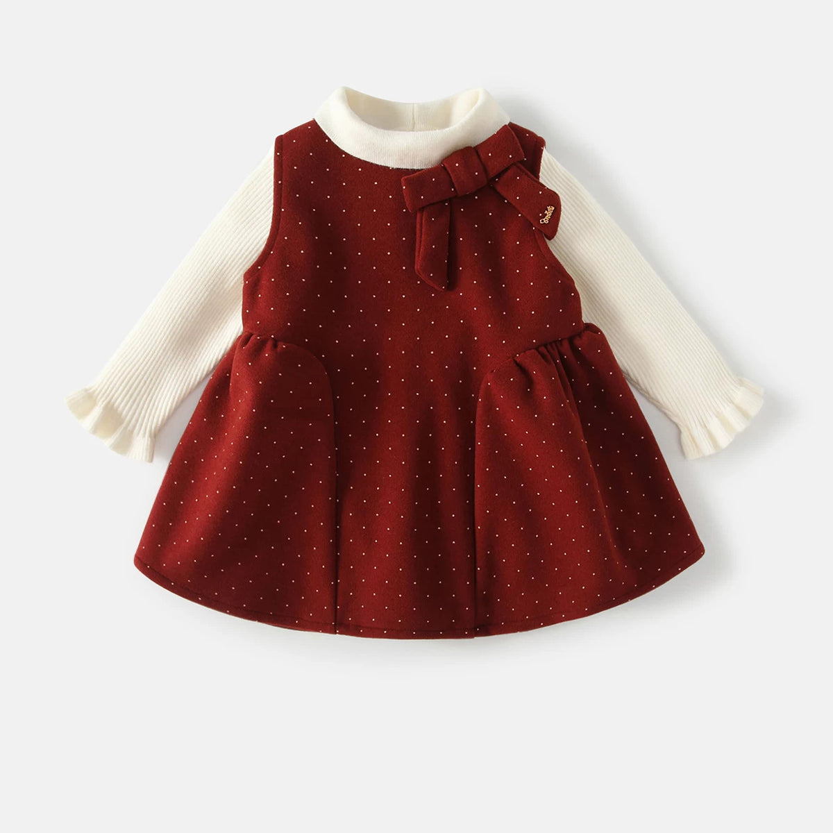 Ruby red dotted pinafore dress with bow over cream ribbed top, girls set flat lay