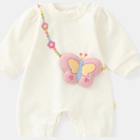 Cream baby romper with flower-chain strap and pink butterfly, close view