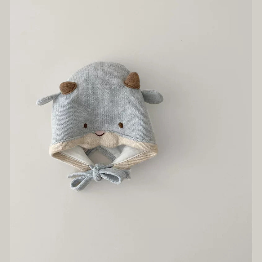 Light blue knit lamb baby bonnet with chin ties, flat lay
