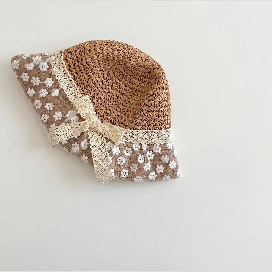 Caramel straw baby sun hat with floral lace brim and lace bow, flat lay