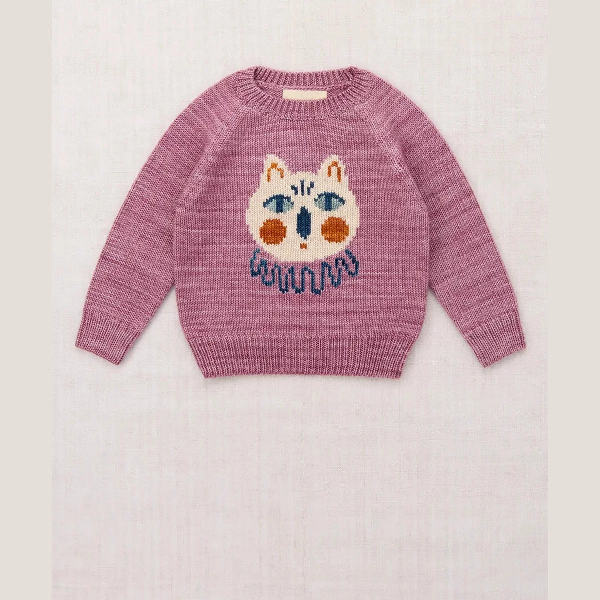 Berry pink kids knit sweater with a cream cat face, flat lay