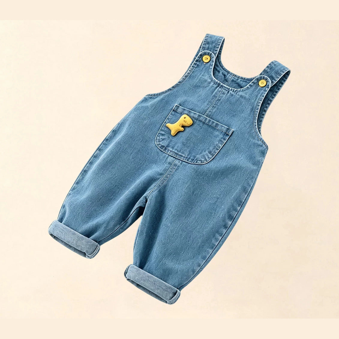 Toddler denim dungarees with dino pocket and rolled cuffs, angled flat lay