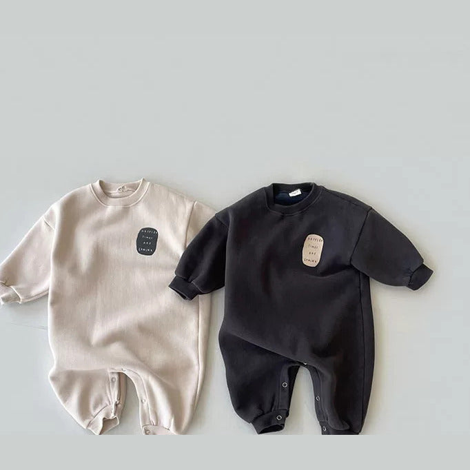 Beige and charcoal fleece-lined sweatshirt baby rompers side by side, flat lay