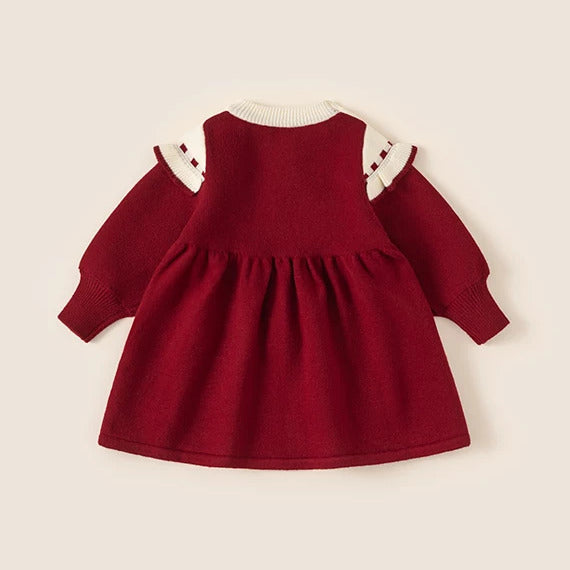 Back of red knit girls dress with cream ruffle cape collar