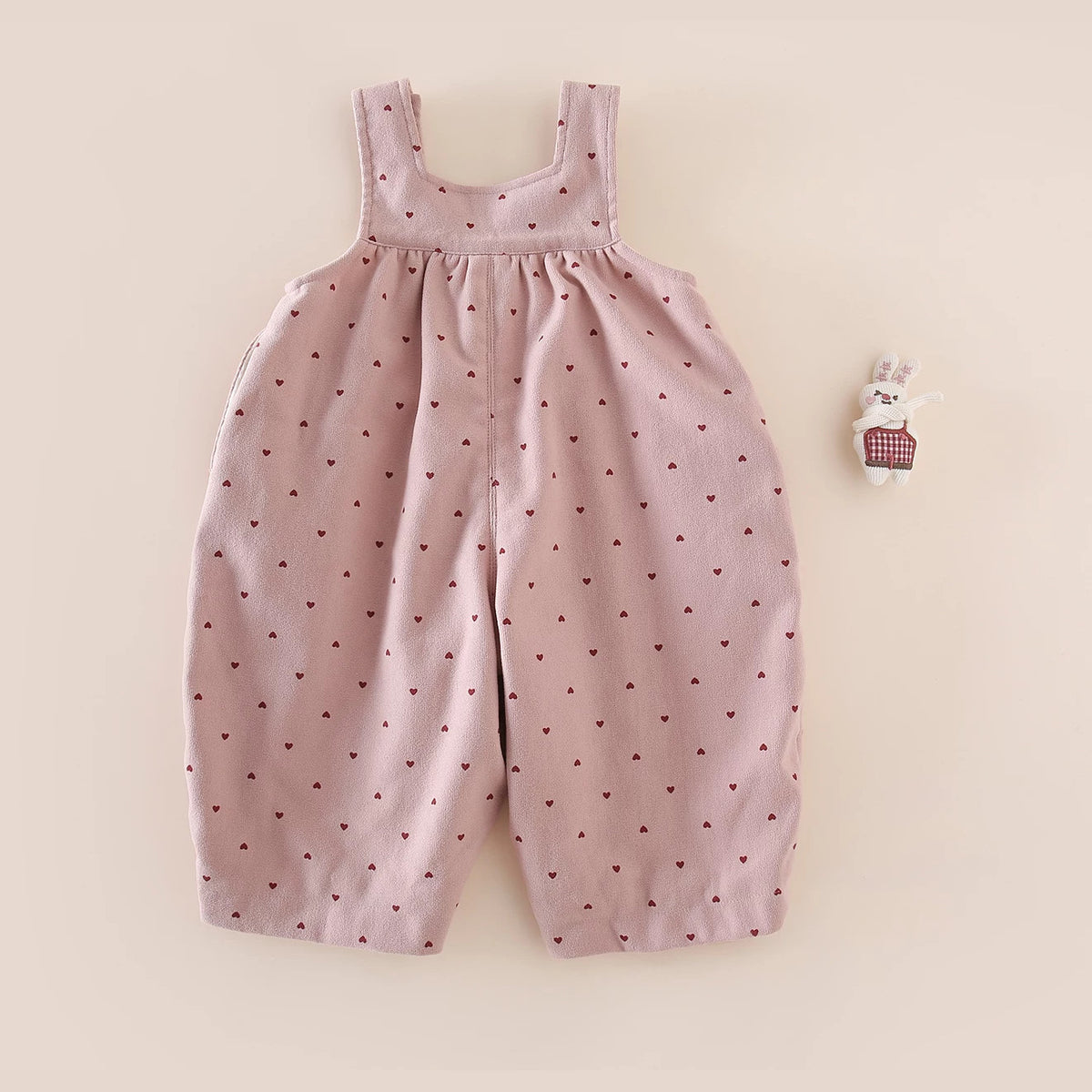 Back view of pink heart-print baby overalls with wide straps
