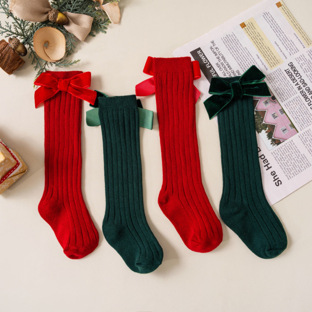 Red and green ribbed knee-high baby socks with velvet bows