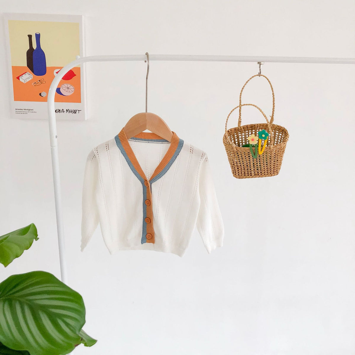 White knit cardigan hanging on a rail