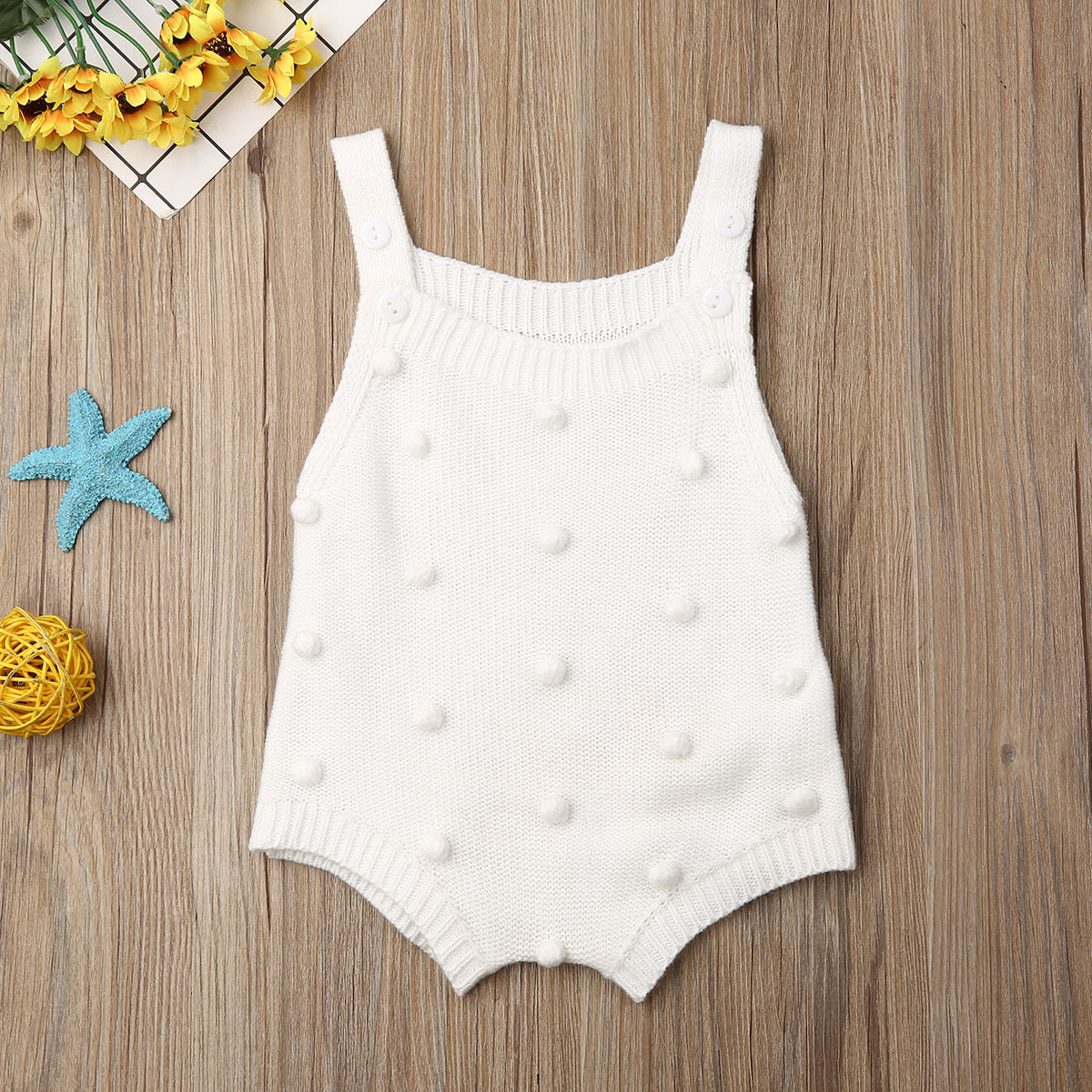 White sleeveless pom-pom knit baby romper