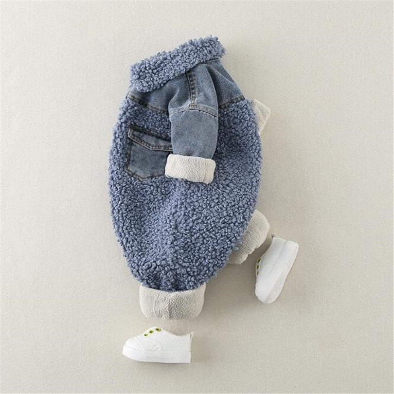 Adorable baby romper in blue sherpa fleece with denim accents, styled with a unique layered look and rolled cuffs, perfect for keeping babies cozy and fashionable in cooler weather. The side view highlights the soft, textured fleece and denim pockets, with added comfort from the cuffed sleeves and ankles. Paired with a small white sneaker, this outfit is ideal for a casual, trendy winter look for babies.