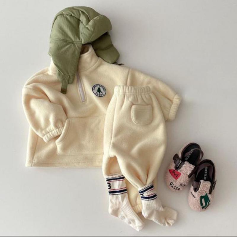 Beige polar fleece baby set styled with a green hat and shoes