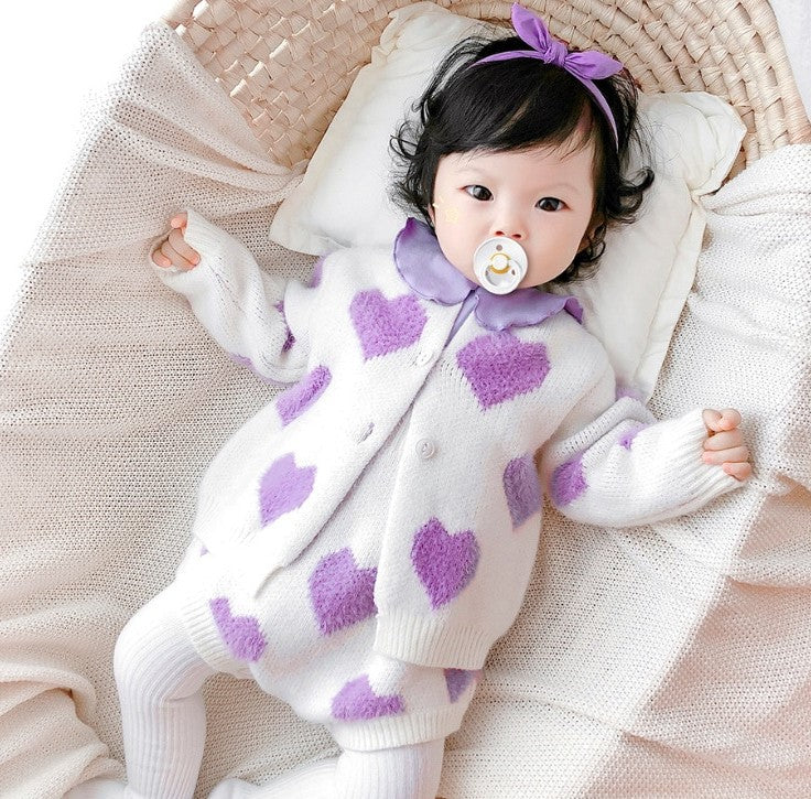 Baby lying in purple heart knit set