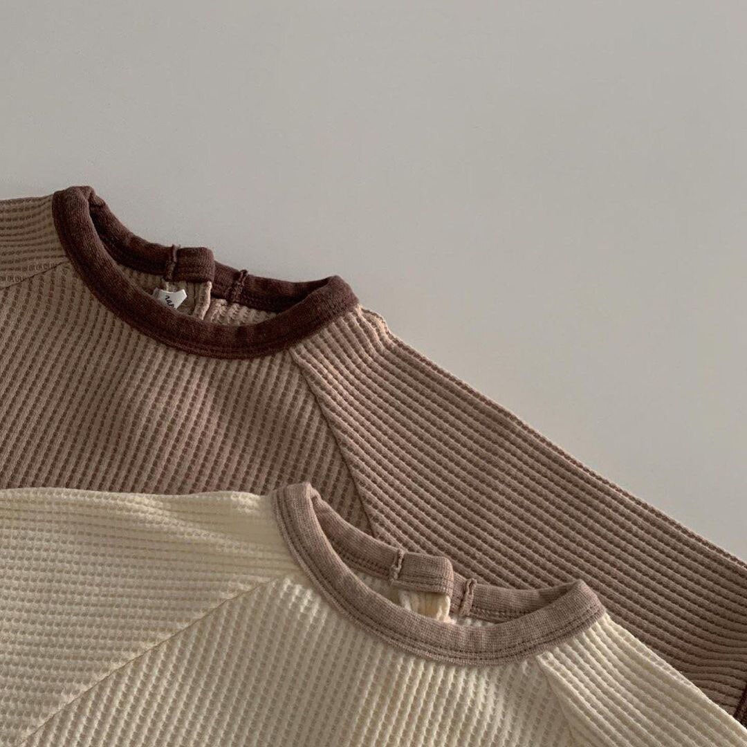 Contrast neckline trim on waffle knit baby rompers