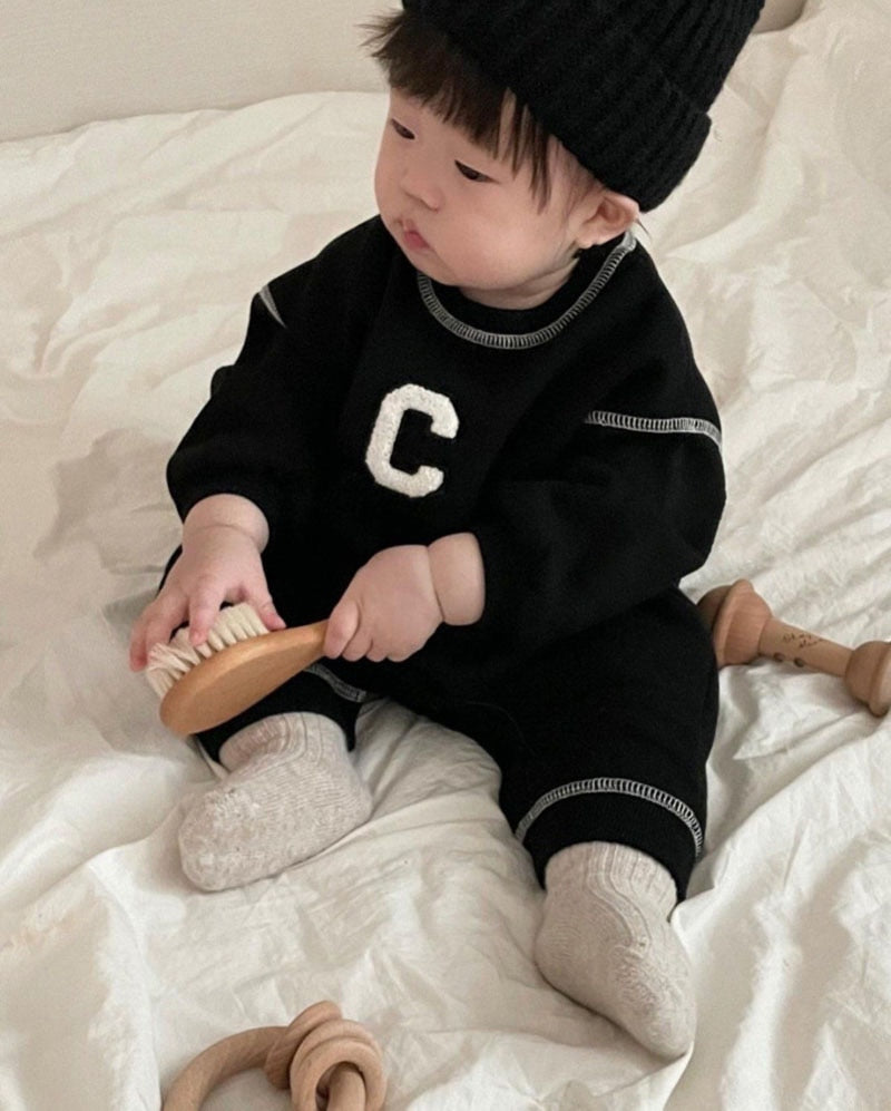 Baby sitting in black C letter jumpsuit