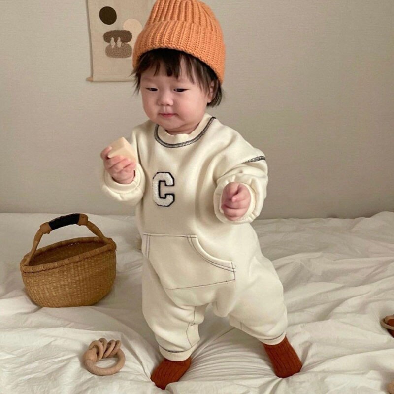 Baby in white C letter jumpsuit close-up