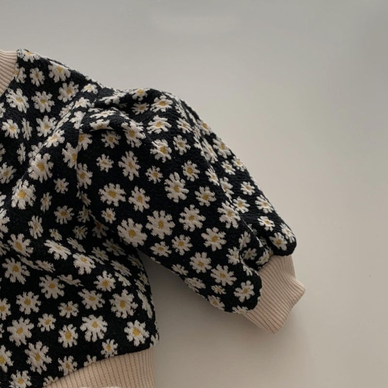 Close-up of black daisy cardigan sleeve