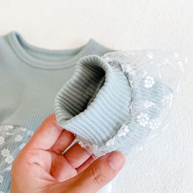 Close-up of blue ribbed cuff and floral lace