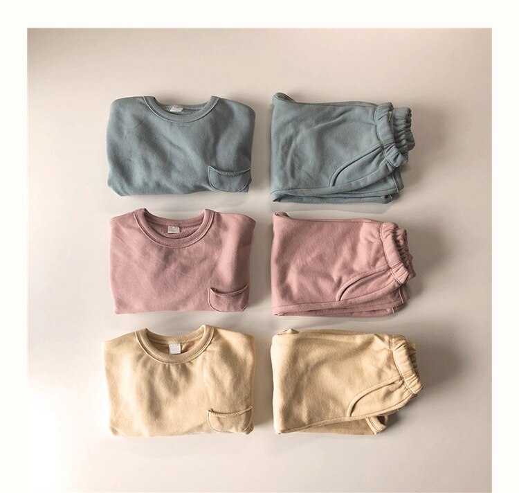 Blue, pink and yellow sweatshirt sets laid flat