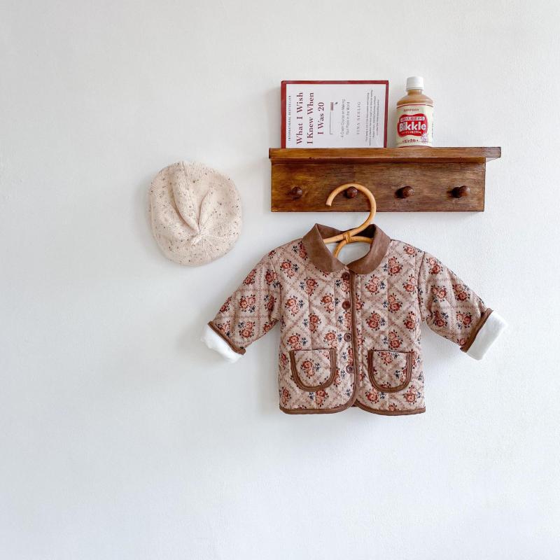 Brown floral quilted jacket on a wall shelf