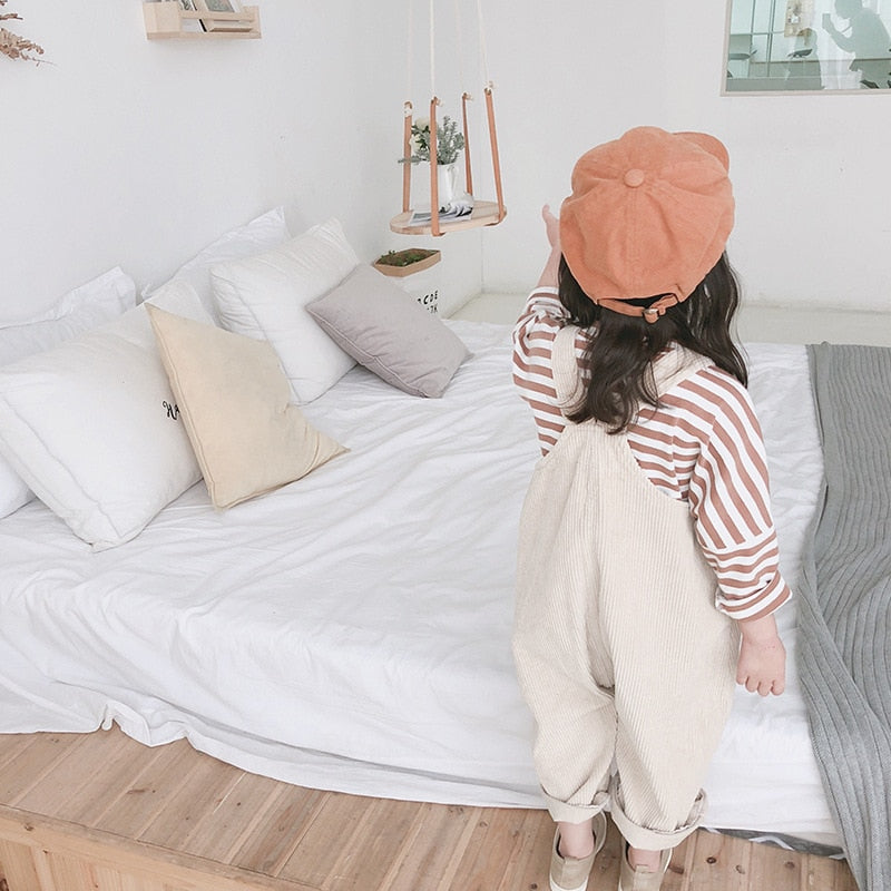 Side view of girl in corduroy overalls