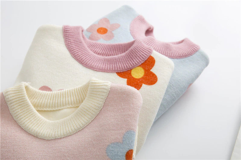 Close-up of necklines on daisy sweaters