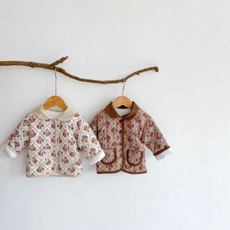 White and brown floral jackets on a branch