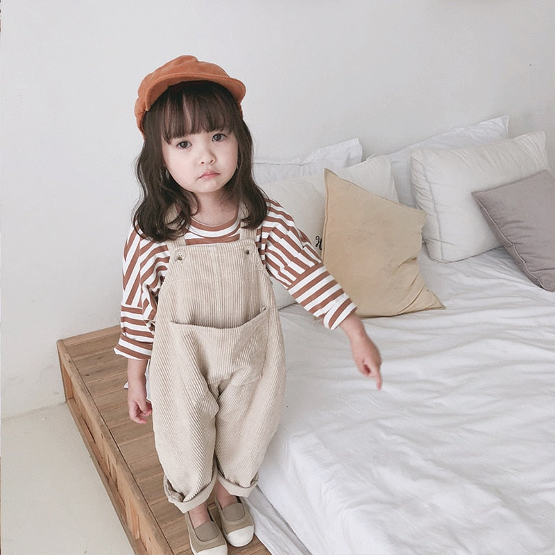 Girl sitting in beige corduroy overalls