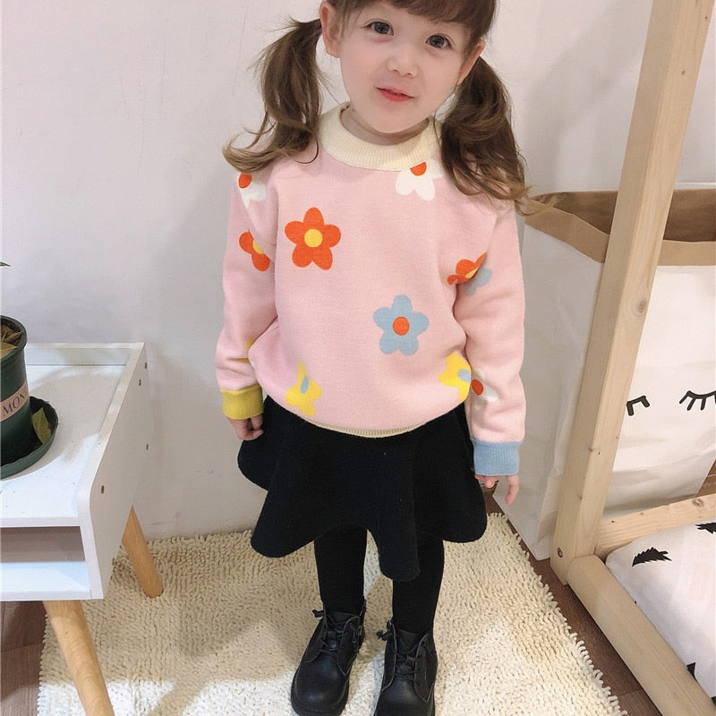 Girl wearing pink daisy knit sweater