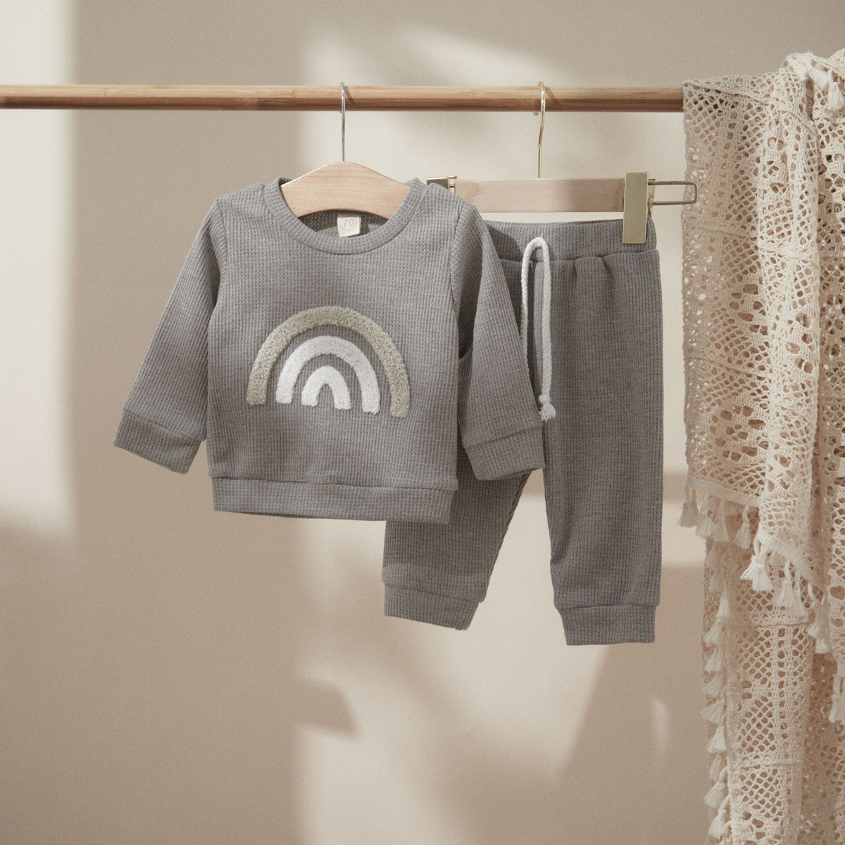 Gray rainbow top and pants on a hanger