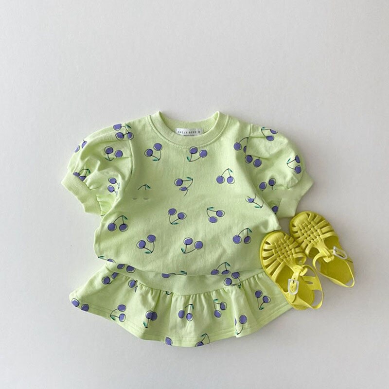 Green cherry print set laid flat with sandals