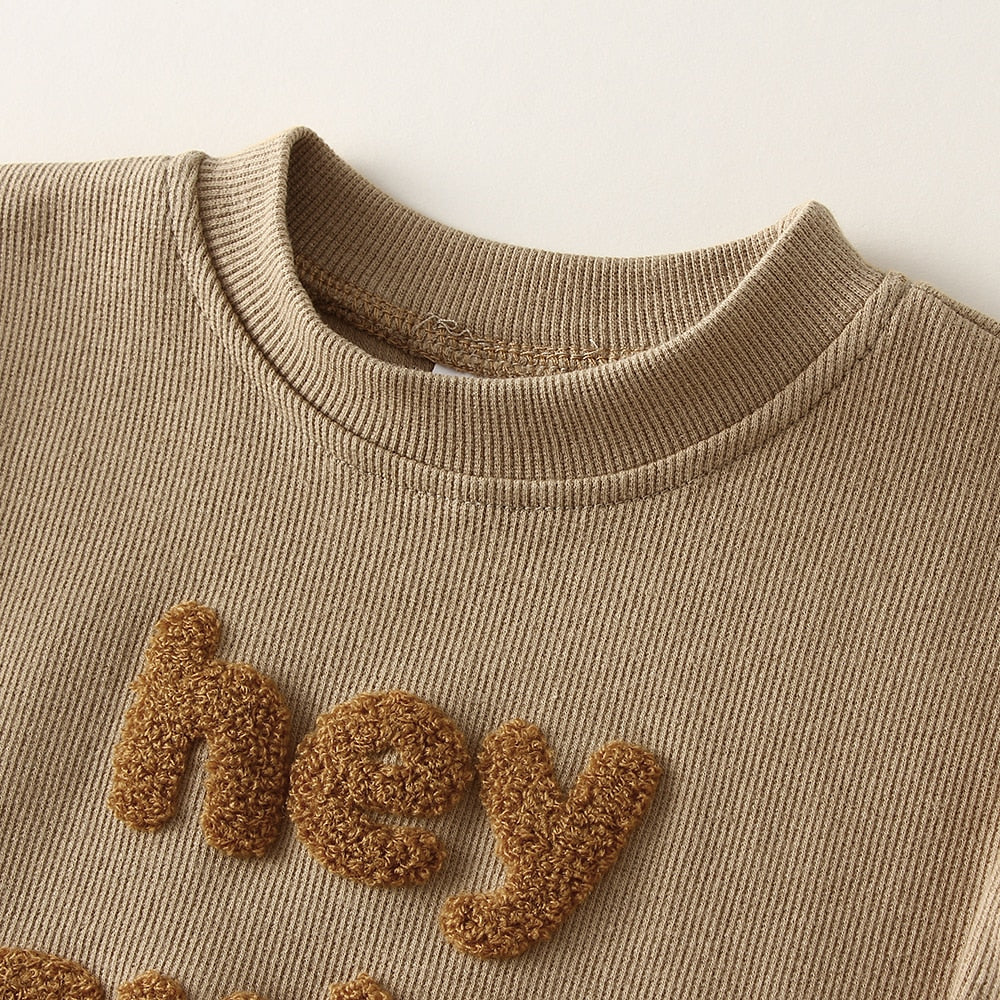 Close-up of fluffy Hey embroidery on waffle fabric