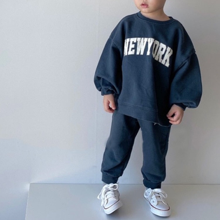 Child wearing dark blue NEW YORK tracksuit