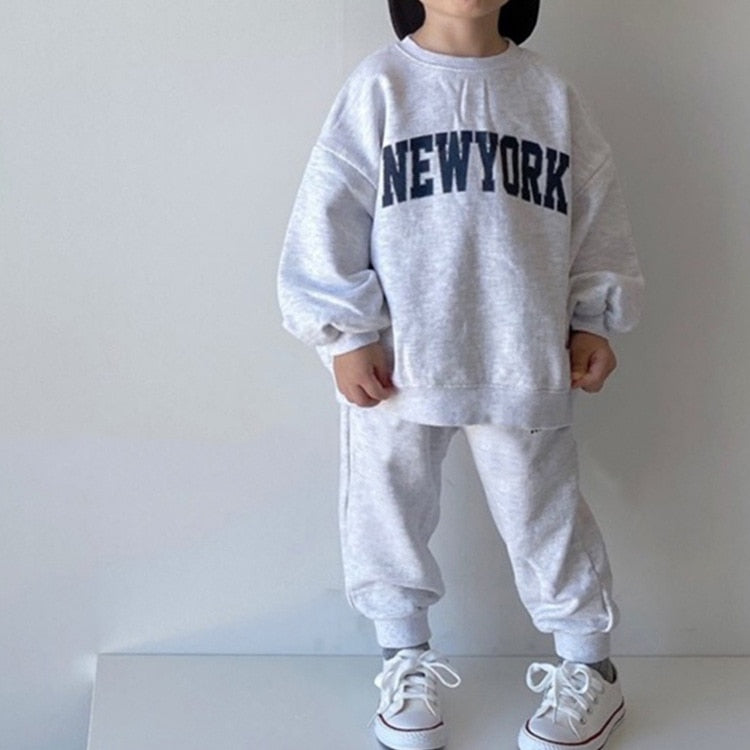 Child wearing gray NEW YORK sweatshirt and joggers