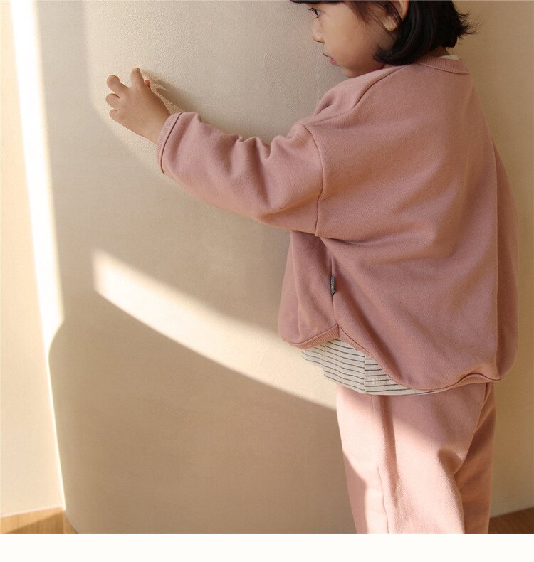 Child in pink sweatshirt set side view