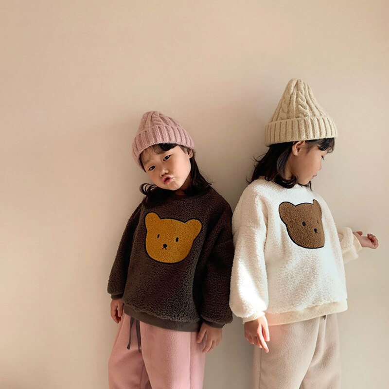 Two kids wearing teddy bear sherpa sweatshirts