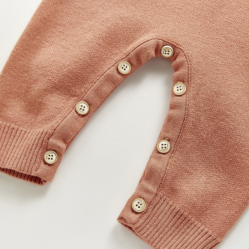Close-up of buttons along knit jumpsuit leg
