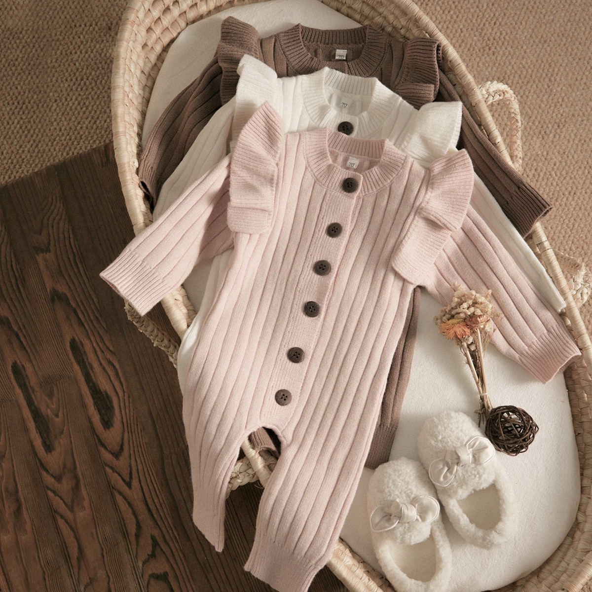 Pink ruffle knit baby jumpsuit in a basket