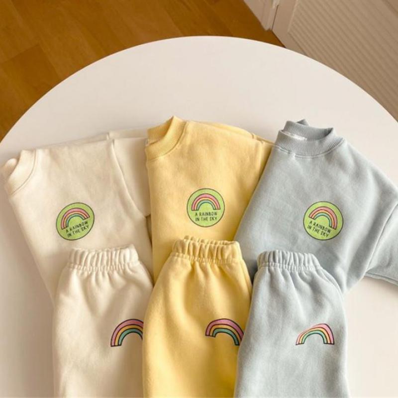Rainbow sweatshirt sets on a round table, front view