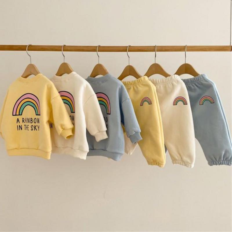 Rainbow sweatshirt and pants sets hanging on a rail