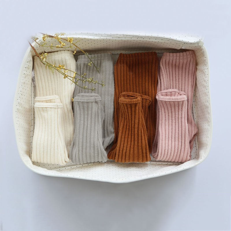 Folded ribbed knit pajamas in a basket
